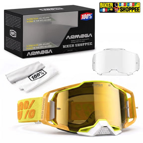 ARMEGA snow goggles with a yellow and orange frame, a gold mirrored lens, a white chin strap, a white replacement lens, a white cleaning cloth, and the black product box on a white background.